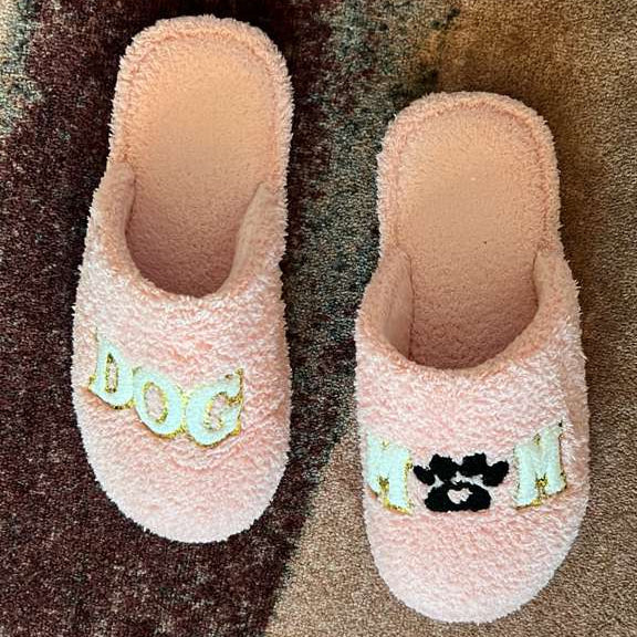 Pair of pink slippers with decorative elements on a textured surface
